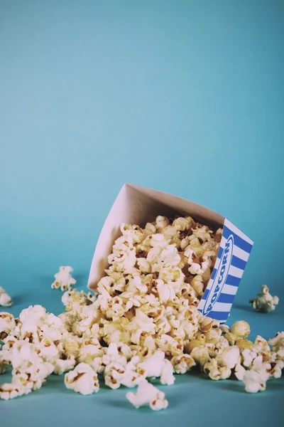 Plechovka popcorn na modrém pozadí Vintage Retro filtru. — Stock fotografie