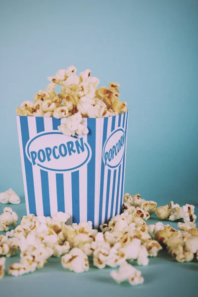 Popcorn bucket against a blue background Vintage Retro Filter.