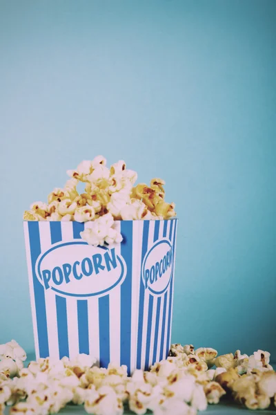 Plechovka popcorn na modrém pozadí Vintage Retro filtru. — Stock fotografie