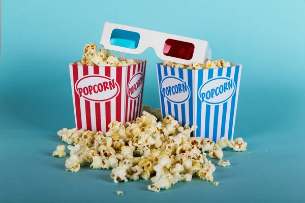 Plechovka popcorn na modrém pozadí — Stock fotografie