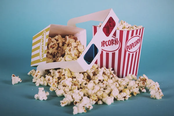 Popcorn hink mot en blå bakgrund Vintage Retro Filter. — Stockfoto