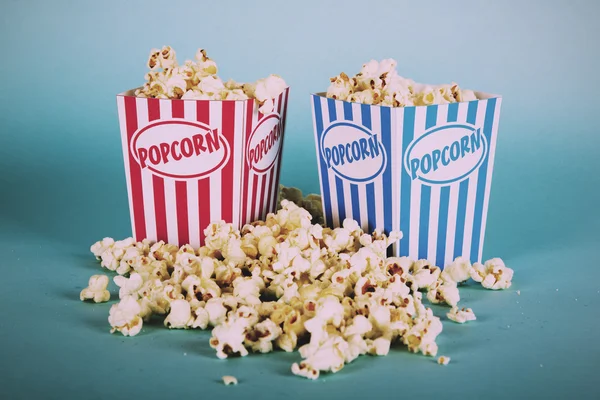 Popcorn hink mot en blå bakgrund Vintage Retro Filter. — Stockfoto