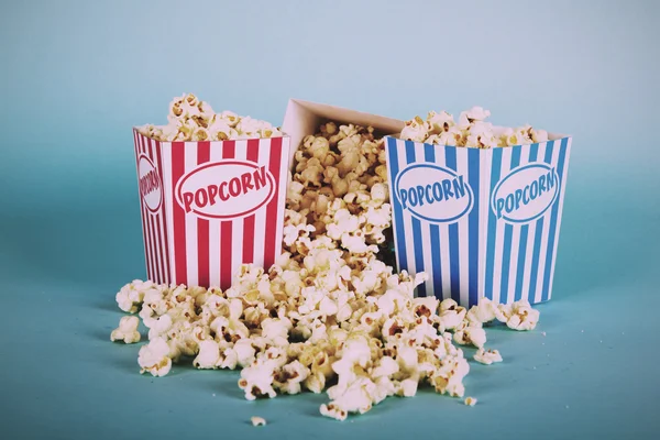 Popcorn hink mot en blå bakgrund Vintage Retro Filter. — Stockfoto
