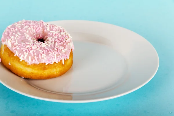 Donut gelado em um fundo azul claro — Fotografia de Stock