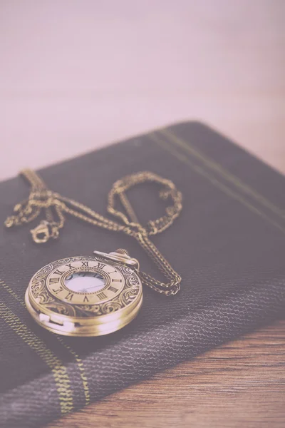 Zakhorloge en boek tegen een rustieke achtergrond Vintage Retro — Stockfoto