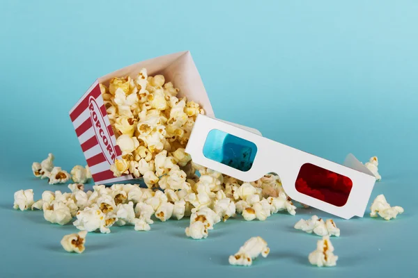 Plechovka popcorn na modrém pozadí — Stock fotografie