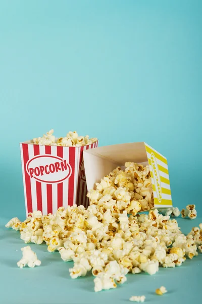 Popcorn hink mot en blå bakgrund — Stockfoto
