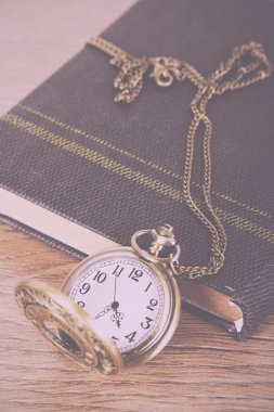 Cep saati ve kitap bir rustik karşı Retro Vintage arka plan 
