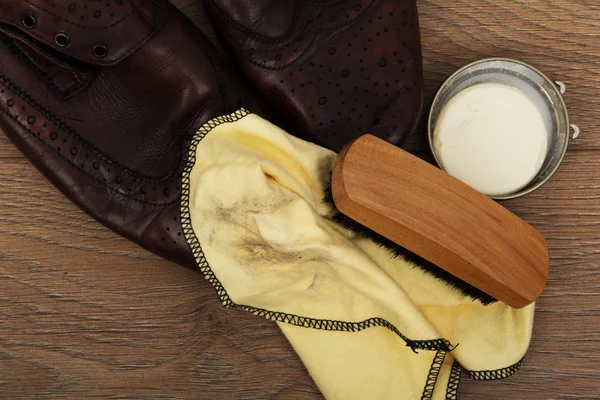 Shoes and cleaning equipment on a wooden floor — Stock Photo, Image