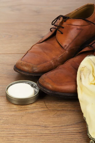 Shoes and cleaning equipment on a wooden floor — Stock Photo, Image