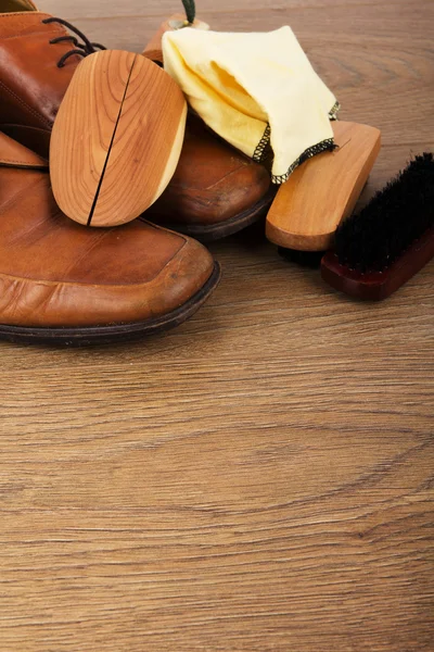 Shoes and cleaning equipment on a wooden floor — Stock Photo, Image