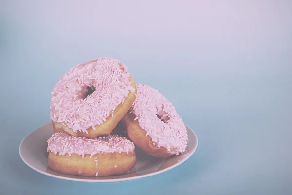 Ciambella ghiacciata su fondo azzurro Vintage Retro Filter . — Foto Stock