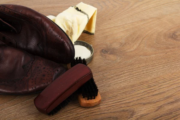 Shoes and cleaning equipment on a wooden floor — Stock Photo, Image