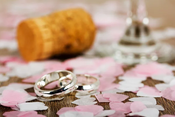 Anillos de boda sobre fondo de madera con confeti — Foto de Stock
