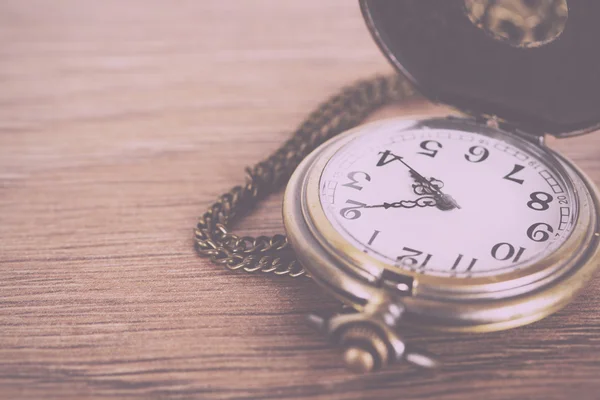 Pocket watch against a rustic background Vintage Retro Filter. — Stock Photo, Image