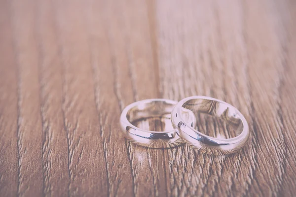 Par de anillos de boda sobre un fondo de madera Vintage Retro Filte — Foto de Stock