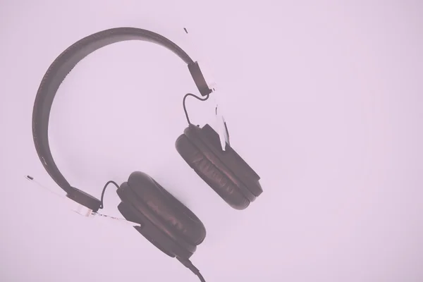 Black headphones against a light coloured background Vintage Ret — Stock Photo, Image