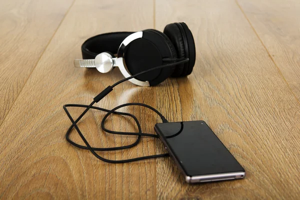 Headphone dan telepon pada permukaan kayu — Stok Foto