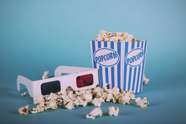 Popcorn bucket against a blue background Vintage Retro Filter. Stock Picture