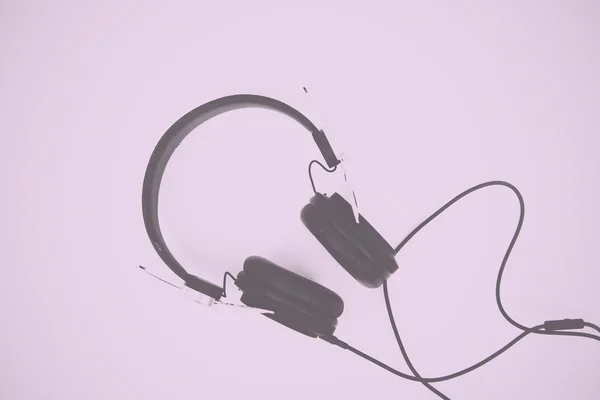 Black headphones against a light coloured background Vintage Ret — Stock Photo, Image