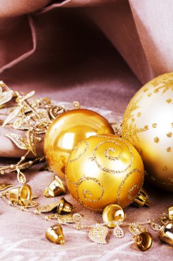 Kumaş arka plan üzerinde şenlikli altın Noel süsleri