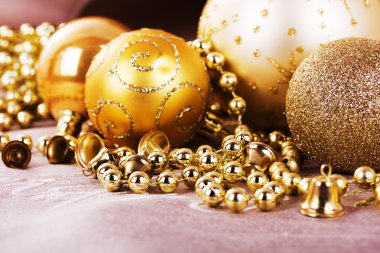 Kumaş arka plan üzerinde şenlikli altın Noel süsleri