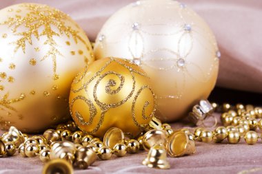 Kumaş arka plan üzerinde şenlikli altın Noel süsleri
