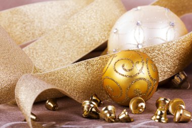 Kumaş arka plan üzerinde şenlikli altın Noel süsleri