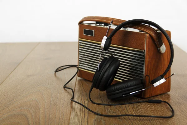 Auriculares y radio antigua en superficie de madera — Foto de Stock