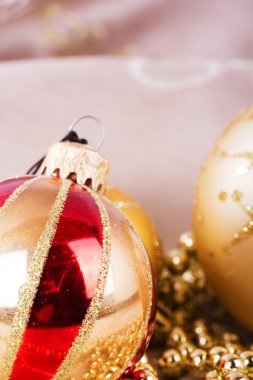 Kumaş arka plan üzerinde şenlikli altın Noel süsleri