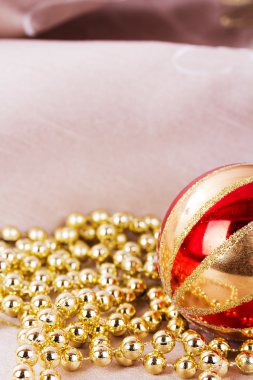 Kumaş arka plan üzerinde şenlikli altın Noel süsleri