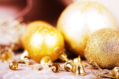 Kumaş arka plan üzerinde şenlikli altın Noel süsleri