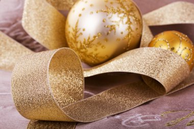 Kumaş arka plan üzerinde şenlikli altın Noel süsleri