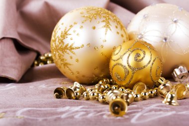 Kumaş arka plan üzerinde şenlikli altın Noel süsleri