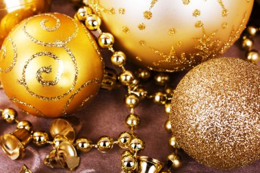 Kumaş arka plan üzerinde şenlikli altın Noel süsleri