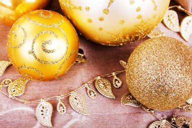 Kumaş arka plan üzerinde şenlikli altın Noel süsleri