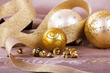 Kumaş arka plan üzerinde şenlikli altın Noel süsleri