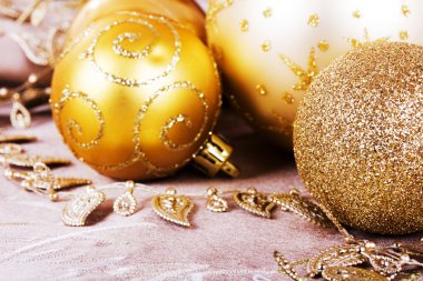Kumaş arka plan üzerinde şenlikli altın Noel süsleri
