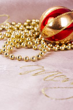 Kumaş arka plan üzerinde şenlikli altın Noel süsleri