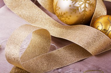 Kumaş arka plan üzerinde şenlikli altın Noel süsleri