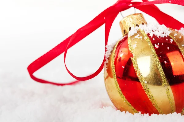 背景の白い雪の中でゴールドのクリスマスの装飾 — ストック写真