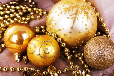 Kumaş arka plan üzerinde şenlikli altın Noel süsleri