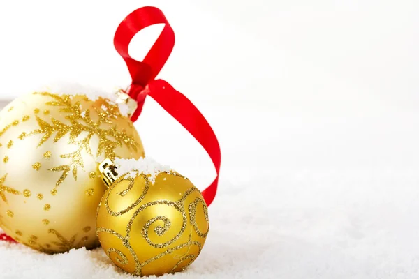 在白雪为背景的黄金圣诞装饰品。 — 图库照片