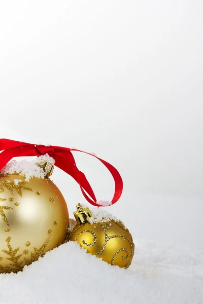 Altın Noel süslemeleri için arka plan beyaz karda — Stok fotoğraf