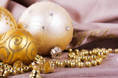 Kumaş arka plan üzerinde şenlikli altın Noel süsleri