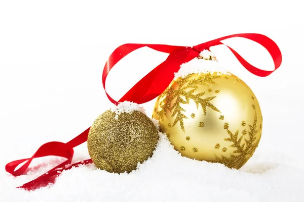 Золоті різдвяні прикраси в білому снігу для фону — стокове фото