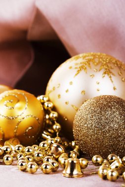 Kumaş arka plan üzerinde şenlikli altın Noel süsleri