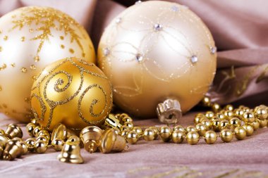 Kumaş arka plan üzerinde şenlikli altın Noel süsleri
