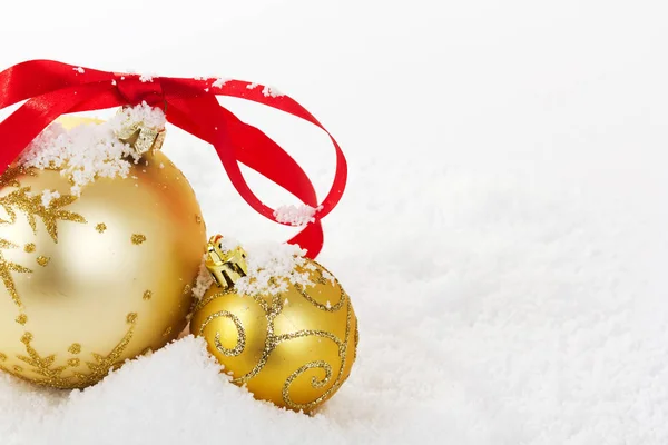 在白雪为背景的黄金圣诞装饰品。 — 图库照片