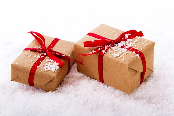 Vánoční dárky do balicího papíru s červenou stužkou — Stock fotografie